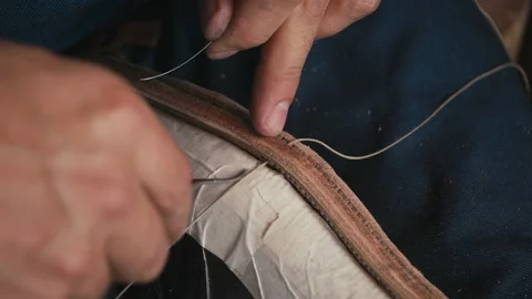 Close up shoemaker's hands stitching shoe with awl and thread. Workshop hipsters Stock Footage 138235448
