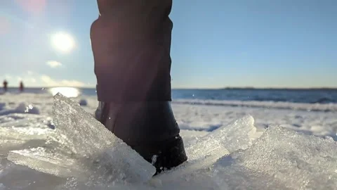 Close-up of shoes breaking on fresh ice sparkling in the sun Stock Footage 254432896