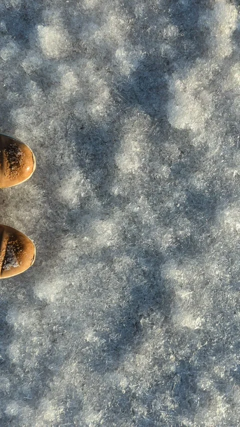 Close-up of shoes breaking on fresh ice sparkling in the sun Stock Footage 254433341