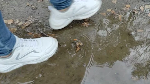 Close-up of shoes walking through puddles Stock Footage 152531174