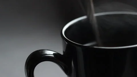 Close up shoot with black cup of coffee. Stir the cappuccino with a spoon Stock Footage 86011050