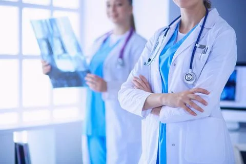 Close up shoot of doctor's crossed hands and colleague with x-ray on the Stock Photos