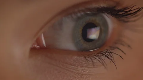Close-up shoot of eye watching rightwards being concentrated in red and yellow 動画素材 109107812