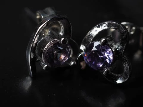 Close up shoot of silver earring with faceted amethyst gem Stock Photos