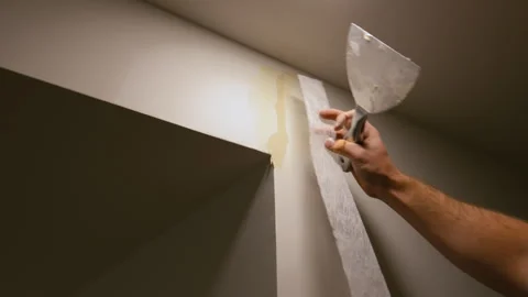Close up shoot of Worker applying wall putty with a spatula to repair surface Видео 332185837