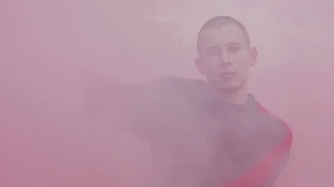 Close-up shoot of young cheeky dancing man with a lot of color smoke in slow Stock Footage 105463656
