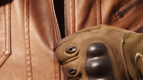 Close shoot zipping up a leather jacket, of a young handsome bearded biker. Stock Footage 152983308