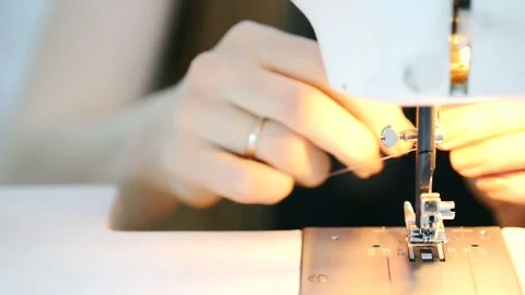 Close-up shooting hands putting pink thread in sewing machine Video stock 78631176