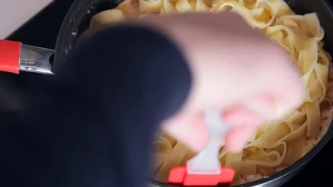 Close up shooting of man hands cooking pasta in pan on stove Stock Footage 72523973