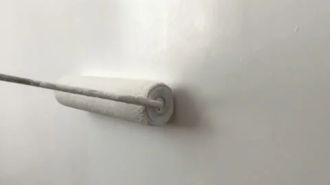 Close Up shooting. Painter paints wall with a paint roller Stockbeeldmateriaal 202006609