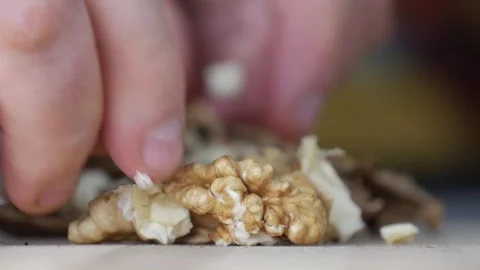 Close-Up Shooting Selecting Cracked Walnuts from the Table. Chopped Nuts Opened Stock Footage 328968093