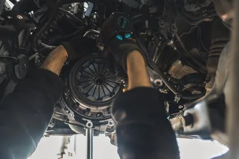 Close shop of two gloved hands doing a clutch replacement. Repair shop concept. Stock Photos