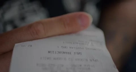 Close-Up of Shopper Hands Holding Long Printed Receipt... Vidéo 329253702
