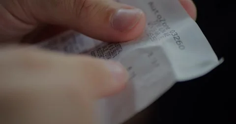 Close-Up of Shopper Hands Holding Long Printed Receipt... Stock Footage 329253704