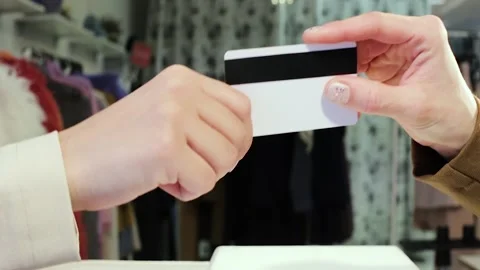Close-up of a shopper paying for her purchase by a credit card Stock Footage 95675147