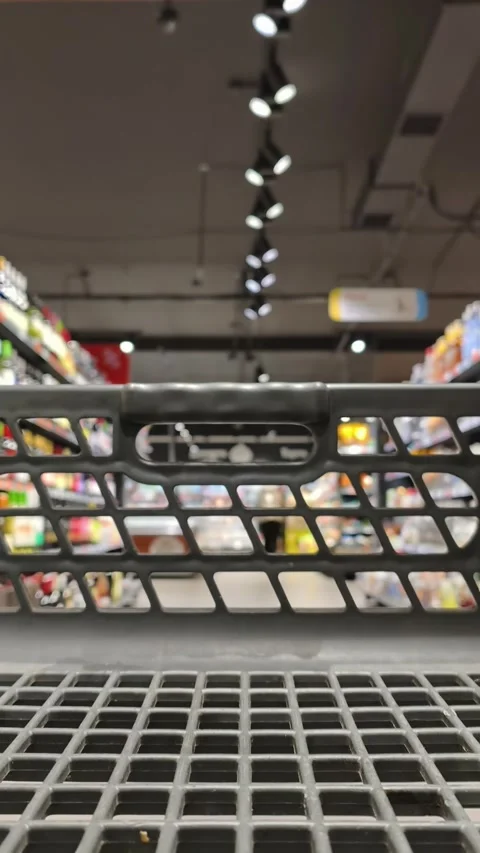 Close Up of Shopping Cart Handle Inside Supermarket with Blurred Aisle Vidéo 333827449