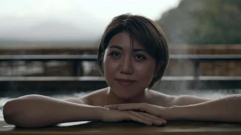 Close up shot on 4k RED camera. A pensive Japanese woman in a sitting in a hot w Stock Footage 199459112