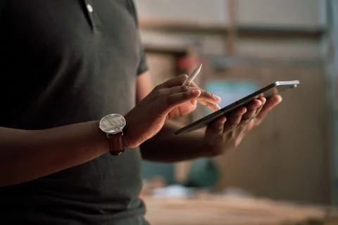 Close up shot of African man using tablet in a carpentry factory Stock Photos