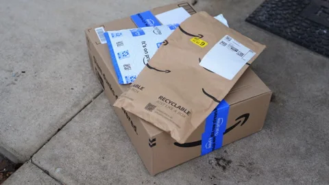 Close up shot of Amazon delivery package with padded envelopes left on a Stock Footage 330985973