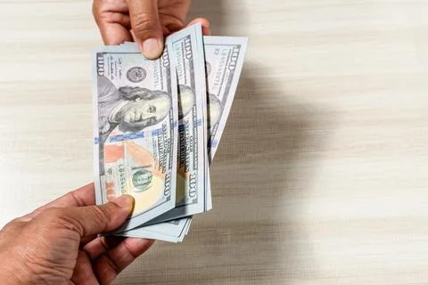 Close-up shot and select focus Concept of holding 100 dollar bills to buy a.. Stock Photos