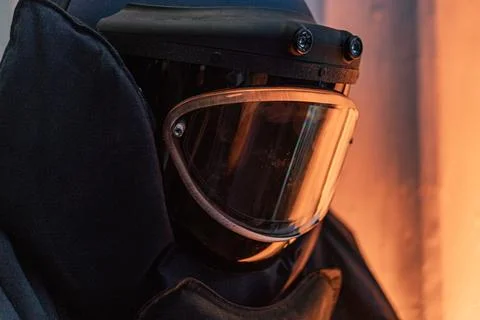 Close-up shot of an anonymous deminer in an EOD suit, with a blurred backgrou Stock Photos