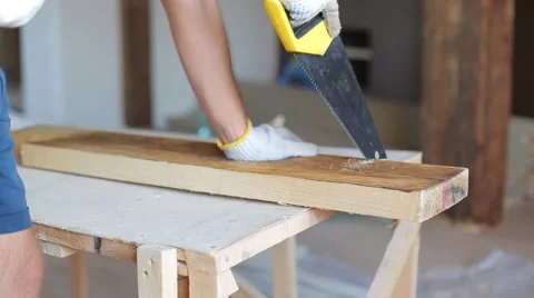 Close up shot of arms sawing through a wooden siding panel Stock Footage 67894475