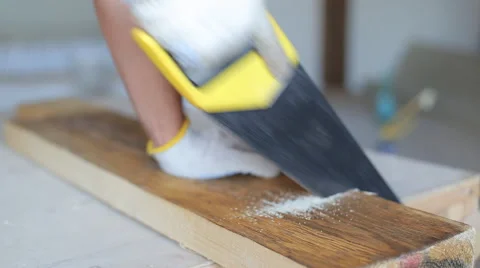 Close up shot of arms sawing through a wooden siding panel Stock Footage 67894711