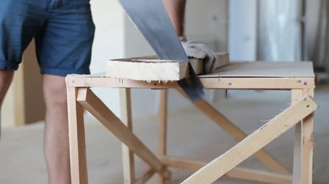 Close up shot of arms sawing through a wooden siding panel Stock Footage