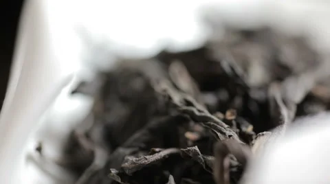 Close up shot of aromatic black loose tea leaves pile on light background Stock Footage 56353696