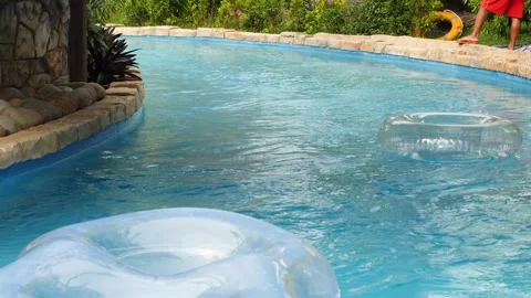 Close up shot of artificial lazy river in the water park with moving floaters. Stock Footage 147068817