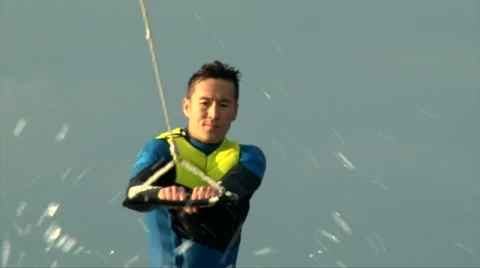 Close up shot asian man in diving suit wake boarding behind the speed boat Stock Footage 66975074