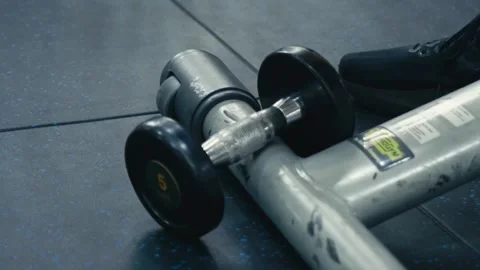 Close up shot of an athlete's hand reaching down and grabbing a 5kg dumbbell Stock Footage 346311352