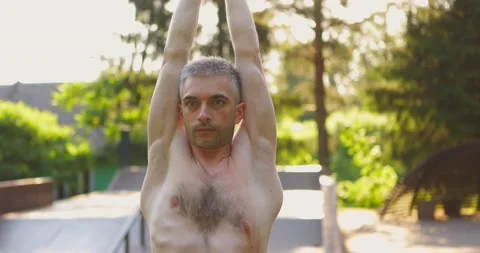 Close-up shot of Athletic man doing yoga pose and pilates exercises in nice Video stock 157992794