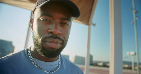 Close up shot of attractive man face African-Amercan in cap looking to camera Stock Footage 140737973