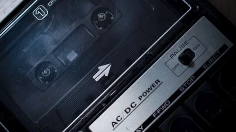 Close Shot of Audio Cassette Spooling in a Retro (1970s) Portable Recorder Stock Footage 107825235