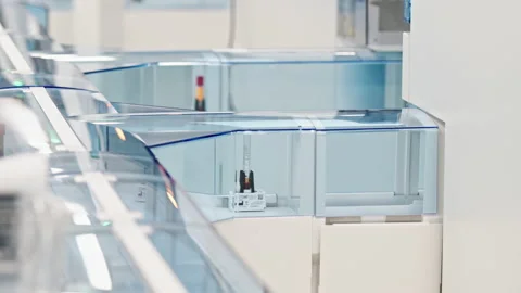 Close shot of an automated lab with test tubes moving on a line behind the glass Stock Footage 232689084