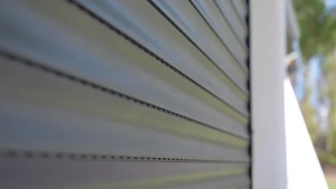 Close-up shot of a automatic garage door closing with bright sunlight Stock Footage 275250478