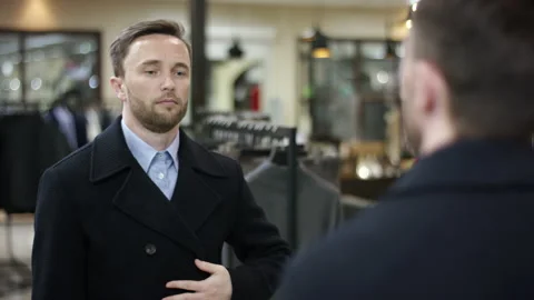 A close up shot from the back of a dark haired businessman in a clothing shop Stock Footage 140616902