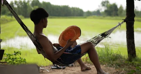 Close up shot, Back view of Young farmer man without shirt sit on the hammock Stock Footage 202054535