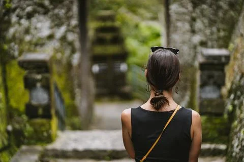 Close up shot of back view of young lady with balinese temple background Stock Photos