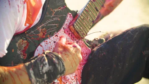 Close up shot of a badly wounded man playing a broken electric guitar Видео 293113621