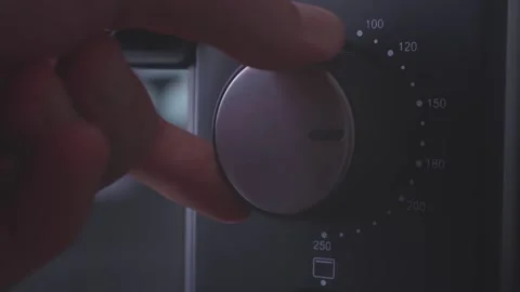 Close up shot of a baker's hand setting the timer knob of a modern convection 動画素材 145841151