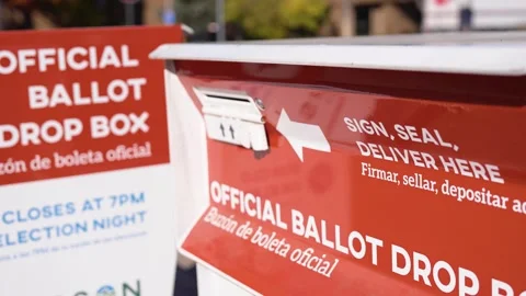 Close shot of a ballot drop box with official voting signage, showing election Stock Footage 331744280