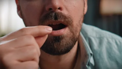 Close up shot of bearded man sitting on couch, man taking and eating potato Stock Footage 305495394