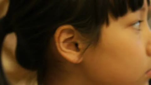 Close-up shot of beautiful little oriental girl looking around Stock Footage