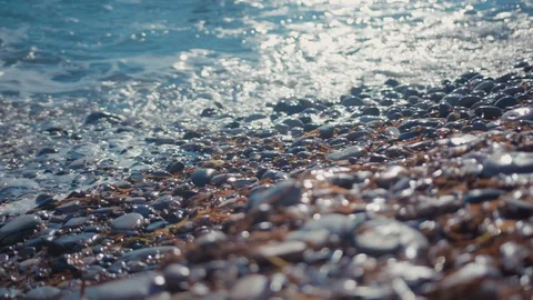 Close-up shot of beautiful sea waves approaching and crashing on rocky beach Video stock 124934375