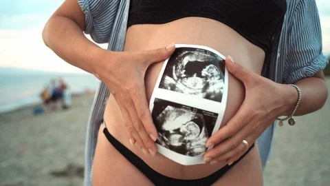 Close-up shot of beautiful tiny woman's belly and sonogram photo, pregnant woman Video stock 118275258