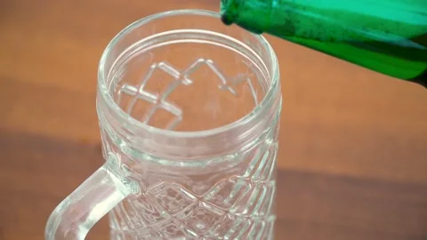Close-up shot of beer is poured into a beer glass with a handle. Warm wooden Video stock 136593155