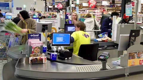 Close shot from behind of a Carrefour employee scanning and assisting customers Stock Footage 330992081