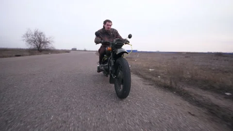 Close shot from below angel a dynamic moving biker on vintage motorcycle Stock Footage 152983588